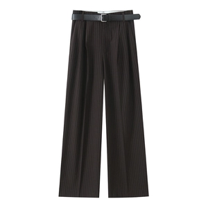 Dettaglio di pantaloni scuri gessati con cintura in pelle nera e pieghe centrali decise