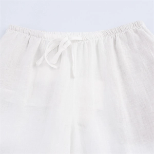 Detail of the elastic waistband with adjustable drawstring on white linen pants