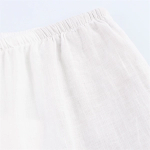 Close-up of elastic waistband with stitching on white linen wide-leg trousers