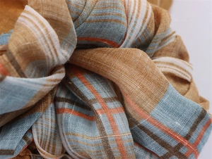 Macro view of woven ramie linen plaid fabric with mustard yellow and blue check pattern