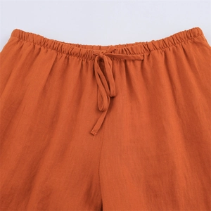 Detail of caramel orange linen wide-leg trousers with elastic drawstring waistband