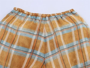 Detail of high elastic waistband on checkered linen lantern pants with orange stripes