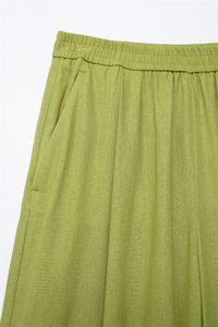 Detailansicht der grasgrünen Leinenhose mit weitem Bein, elastischem Bund und Taschen