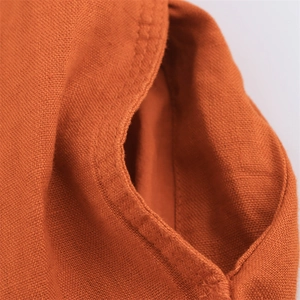Detailed macro view of caramel linen fabric showing pocket stitching and natural texture