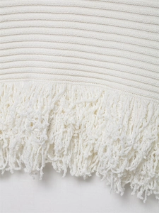 Detailaufnahme von weißem Strickstoff mit horizontalen Streifen und langen Fransenakzenten