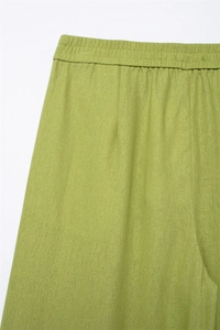 Detail der grünen Leinenhose mit weitem Bein, elastischem Bund und Stoffstruktur