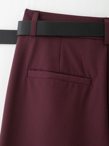 Dettaglio vita pantaloni bordeaux con cintura nera coordinata e tasca a filetto posteriore