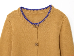 Dettaglio del cardigan in maglia cammello con cuciture a contrasto blu sulla scollatura
