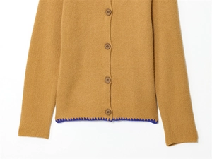 Dettaglio ravvicinato di un cardigan in maglia cammello con bordi a contrasto blu navy