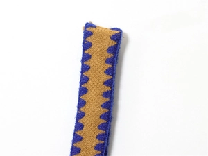 Dettaglio macro del tessuto a maglia blu navy e cammello con ricamo a zigzag e texture