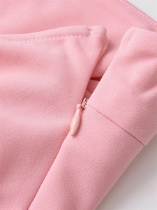 Detail of invisible zipper closure on pink slim fit top with textured woven fabric