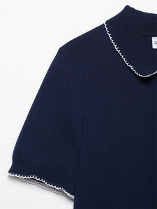 Détail du cardigan en maille bleu marine avec bordure crochetée blanche et texture côtelée
