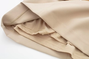 Detailed close-up showing precision stitching and beige fabric lining of the dress