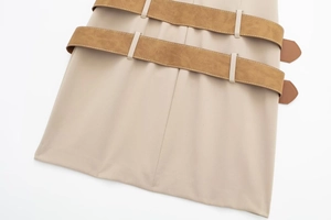 Detailed macro view of the chic double brown suede waist belts on a beige dress