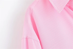 Dettaglio ravvicinato delle strisce rosa e bianche su una camicia in misto cotone