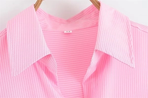 Dettaglio del colletto e dell'etichetta taglia M su una camicia a righe rosa