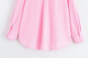 Dettaglio di camicia a righe rosa con orlo curvo e polsini con bottoni in cotone misto
