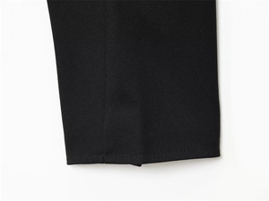 Close-up of black jacket cuff showing detailed twill texture and precision stitching