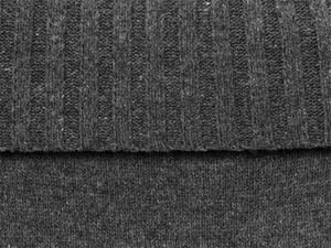 Close-up of dark grey sweater showing ribbed knit texture and soft fabric details