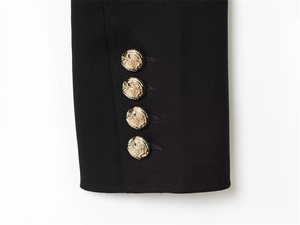 Detail of black jacket cuff with four gold embossed crest buttons on twill fabric