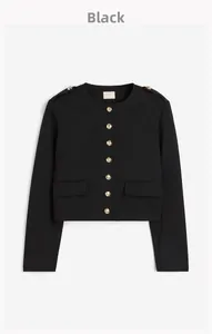 Detail of black cropped jacket featuring embossed gold buttons and epaulettes on shoulders
