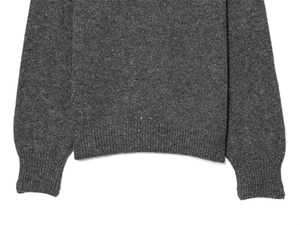 Detail of ribbed hem and cuffs on dark gray knit sweater with fine textured weave