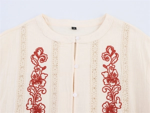 Detail of red floral embroidery and lace hollow-out on beige long sleeve shirt