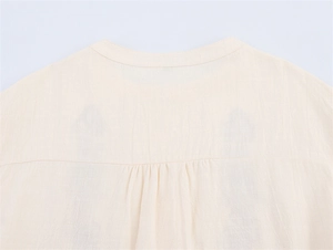 Detail view of round neckline and back pleats on beige summer cotton linen blouse