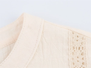 Close-up of beige linen shirt featuring delicate lace embroidery and stand collar detail