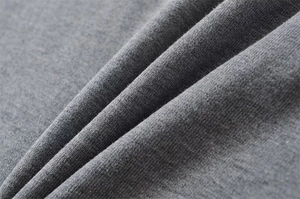 Close-up of premium dark grey knit fabric texture with soft drapes for high-quality clothing