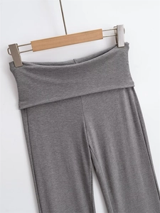 Detailed view of high-stretch grey flared trousers with wide fold-over waistband design