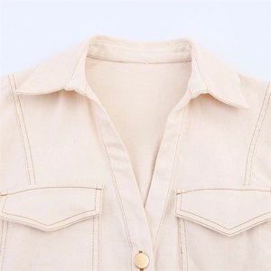Close-up of cream denim midi dress with contrast stitching and chest flap pockets