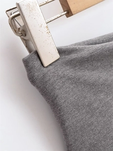 Close-up of grey ribbed knit fabric showing detailed texture and elastic material quality