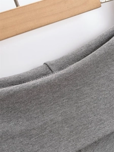 Close-up of gray ribbed knit fabric texture and high-quality stitching on slim-fit trousers