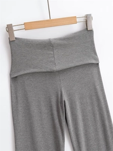 Close-up of grey knit flared trousers with a high-waisted folded waistband design