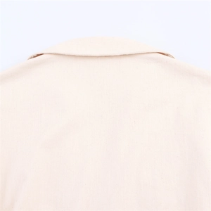 Detailed close-up of classic collar and shoulder seams on cream denim midi dress