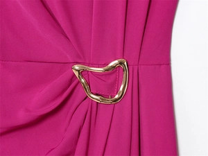 Macro detail of fuchsia sleeveless dress with golden irregular metal buckle and pleats