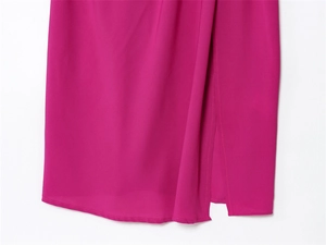 Detail view of fuchsia sleeveless dress featuring a side slit and textured fabric