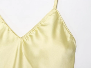 Détail d'une robe en satin champagne avec décolleté en V et fines bretelles