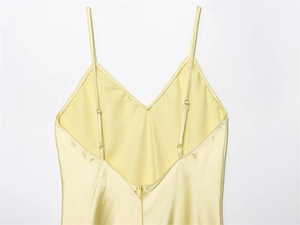 Détail de la robe en satin jaune clair montrant le décolleté en V et les fines bretelles