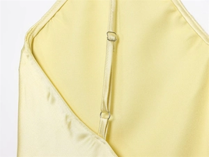 Détail des bretelles réglables sur une robe en satin jaune pâle soyeux avec boucles en métal