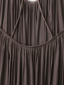 Vista de detalle de tela plisada marrón oscuro con tirantes finos y costuras