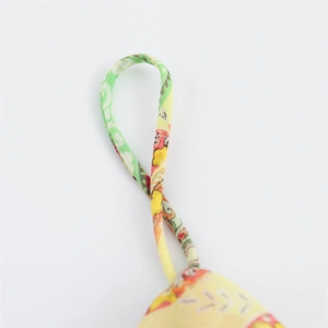 Macro shot of the sturdy stitched hanging loop detail on a colorful printed fabric dress