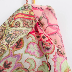 Macro shot of colorful Paisley patchwork floral pattern on lightweight woven dress fabric
