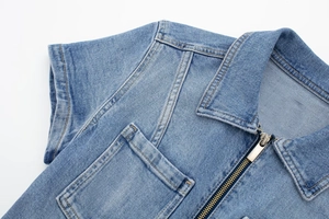 Détail d'une combinaison en denim bleu clair avec fermeture éclair et col à revers