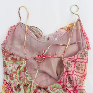 Detail view of pink paisley dress showing slim spaghetti straps and crisscross tie back