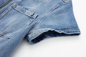 Détail du denim délavé bleu clair avec fermeture éclair métallique et coutures précises