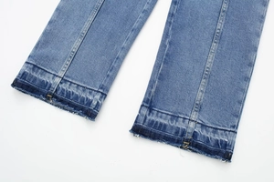 Détails du bas de combinaison en jean avec coutures centrales et ourlet effiloché usé