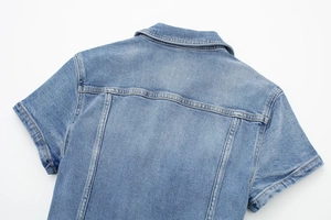 Détail du col d'une chemise en jean bleu clair et coutures d'empiècement au dos