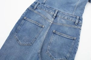 Détail d'une combinaison en jean bleu clair avec coutures orange et poches arrière